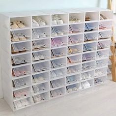 a white shelf filled with lots of clear bins