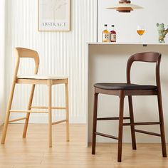 two wooden stools sitting next to each other in front of a bar