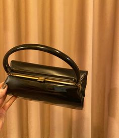 Black vinyl lines the bag's exterior and interior. Compact yet easily spacious for personal items. Gold metal seamlessly interacts where the clasp takes place. 60s Mod, Black Vinyl, Clutch Handbag, Hand Bag, Evening Bags, Purses And Handbags, Clutches, Gold Metal, Display Homes