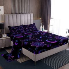 a bed room with a neatly made bed and a night sky scene on the wall