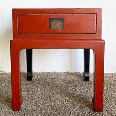 an old red wooden table on carpeted floor