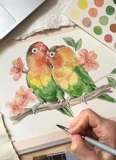 a person is painting two birds on a branch