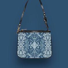 This unique and vibrant shoulder bag adds a chic touch to any outfit. Its compact size (10"w x 8"h) and lightweight construction makes it the perfect accessory for carrying around your essentials in style. Our one of a kind purse features an archival fabric design in baroque flourishes of sapphire, sky and pale blues. This gorgeous design is printed onto high-grade vegan leather and shipped to you by our top-rated production partner. We also offer the coordinating vegan wallet: https://thecheekyshedonist.etsy.com/listing/1680599038 .: 100% high-grade vegan leather exterior .: Polyester lining + 20-inch black strap .: Two open pockets inside .: Gold-toned zipper and hardware .: Original + unique art history design exclusively available at The Cheeky Shedonist  Care instructions: avoid prolo Daily Use Shoulder Bag Pouch, Shoulder Bag With Removable Pouch Shaped As Clutch, Trendy Rectangular Shoulder Bag With Zipper Pouch, Trendy Shoulder Bag With Zipper Pouch For Daily Use, Elegant Zipper Pouch Bag For On-the-go, Trendy Pouch Evening Bag For Daily Use, Trendy Zipper Pouch Shoulder Bag, Trendy Satchel Shoulder Bag With Zipper Pouch, Trendy Shoulder Bag With Zipper Pouch