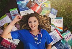 a woman laying on the ground surrounded by books and medical supplies, with her hands behind her head