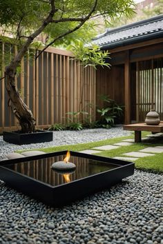 a small garden with rocks, grass and a tree in the center is lit by a candle