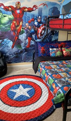 a bedroom with captain america bedding and rugs on the floor in front of a wall mural