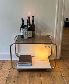 a table that has some wine bottles on it and a light in front of it