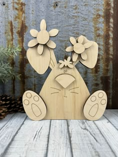 a wooden cutout of a cat with flowers on it's head and paws