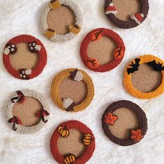 six knitted autumn wreaths arranged on a white surface