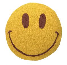 a yellow smiley face rug with two eyes on the front and one eye closed to the side