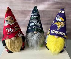 three different nfl gnome hats sitting on top of a table