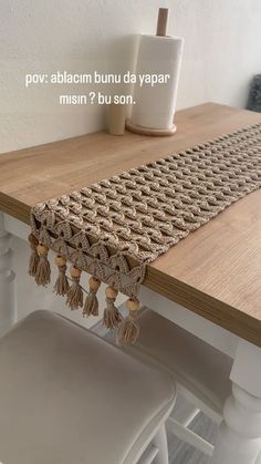 a wooden table topped with white chairs next to a vase