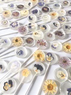 several spoons with flowers on them are lined up in rows against a white background