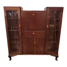 an old wooden cabinet with glass doors on the front and bottom shelves, against a white background