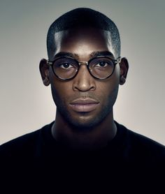 a man with glasses on his face looking at the camera