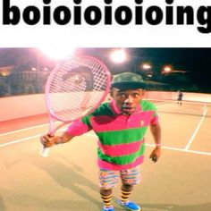 a young man holding a tennis racquet on top of a tennis ball court