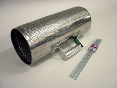 a stainless steel exhaust pipe and some other items on a white table with a toothbrush