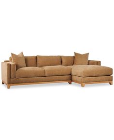 a large sectional couch with pillows on it's back and side facings, sitting in front of a white background