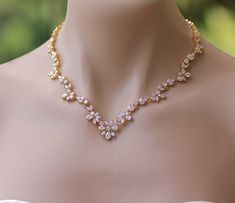 "Marquise cut crystals in a graceful leaf design create the most stunning bridal necklace, with gorgeous sparkle. We have designed this beautiful gold necklace to enhance your décolletage for an elegant and very sophisticated touch to your wedding day jewels. Measures: L = 16.5\" (42 cm) 2\" extender chain is available-see drop menu. 💟 Items that coordinate or are frequently bought together: (some are pictured above) https://www.etsy.com/listing/264959113 https://www.etsy.com/listing/265196688 Yellow Gold Crystal Necklaces For Wedding, Yellow Gold Crystal Necklace For Wedding, Gold Necklace With Sparkling Stones For Wedding, Gold Necklaces With Sparkling Stones For Wedding, Gold Cubic Zirconia Necklace For Wedding, Gold Bridal Necklace With Sparkling Stones For Anniversary, Gold Bridal Necklace With Sparkling Stones For Wedding, Bridal Necklace Gold, Gold Wedding Necklace