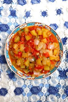 a bowl filled with stew on top of a blue and white table cloth