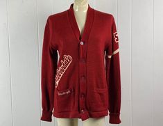 "Vintage 1950s cardigan school Letterman style sweater, cardigan. Made of cranberry red knit wool. Man or woman's sweater, but has a woman's name tag. Has a five button front and two lower pockets. MELVINDALE and JUNE patches, with #54 on left shoulder. Label reads: Yearite Bunny Knits Sportswear, about a size medium.  Actual measurements are:   40\" around the chest   38\" around the waist   19\" shoulder seam to shoulder seam   26\" shoulder seam to end of cuff (when cuffed as pictured)  28\" Retro Long Sleeve Cardigan For College, Red College Sweater For Fall, Red Sweater For College In Fall, Retro Sweater For College In Fall, Vintage Red Fall Sweater, Vintage Sweater For College In Fall, Vintage Sweater For College In Winter, Vintage Fall Sweater For College, Vintage College Sweater For Winter