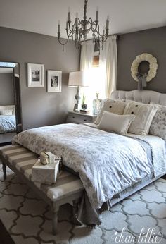 a bedroom with gray walls and white bedding