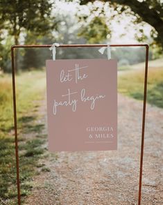 a sign that says let the party begin on it's stand in front of some trees