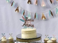 there is a cake and cupcakes on the table with bunting streamers