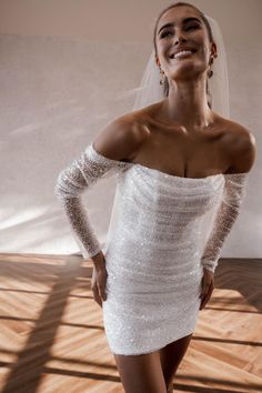 a woman in a white dress posing for the camera