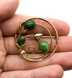 "Vintage Mid Century Krementz Gold Filled Jade Cabochon Leaf Circle Pin Brooch Up for offer is a lovely vintage Krementz yellow gold filled and jade cabochon leaf motife circle pin/brooch. This piece features a safety clasp. Brooch is marked \"Krementz\". Measurements Diameter: 1.35\" inches Jade Cabochons: 7.5mm x 6mm & 10mm x 7.5mm Weight: 5.5 g Condition: Excellent; item is pre-owned and may have some signs of light use. Please look closely at the pictures provided as they are an extensio Mid-century Cabochon Brooch For Gift, Mid-century Cabochon Brooch Gift, Mid-century Cabochon Brooches For Gifts, Collectible Vintage Round Brooches, Vintage Round Brooches For Gifts, Vintage Round Brooches For Anniversary, Jade Brooch, Antique Jewelry Victorian, Art Deco Flower