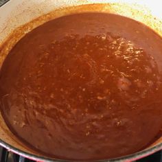 a pan filled with sauce sitting on top of a stove