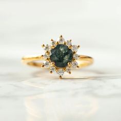 Sometimes when a girl says she likes to receive flowers as a gift, it's not the real flowers she means. Think twice and go for the safest thing - our Flora ring with Moss Agate and Moissanites. Floral jewelry is where it's at! Perfect as a graduation gift, birthday gift, anniversary ring, or promise ring. Details: Center stone Gemstone: Moss Agate Stone Shape: Round Measurements: approx. 6mm Side stones Gemstone: Moissanite Shape: Round Measurements: 2mm (6), 1.5mm (6) Pictured in vermeil, avail Fine Jewelry Cluster Ring With Gemstones For Proposal, Fine Jewelry Gemstone Cluster Ring For Proposal, Gift Sapphire Cluster Ring With Rose Cut Diamonds, Cluster Emerald Ring For Gift, Cluster Emerald Ring With Center Stone For Gift, Cluster Emerald Ring With Center Stone As Gift, Cluster Sapphire Ring With Center Stone As A Gift, Gift Cluster Emerald Ring With Center Stone, Heirloom Sapphire Cluster Ring As Gift