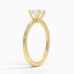 a yellow gold engagement ring with a single diamond in the center, on a white background