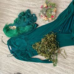 two pieces of clothing on the ground with flowers and other items around them, including hair