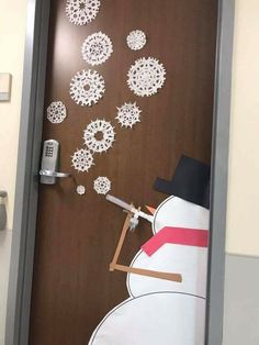 a door decorated with snowmen on the inside and outside, as well as an alarm clock