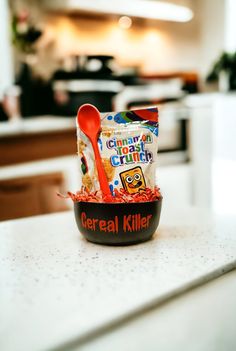 a bowl filled with cereal sitting on top of a counter next to a red spoon