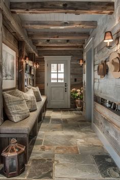 a hallway with wood paneling and stone flooring is decorated in rustic style for the homeowners