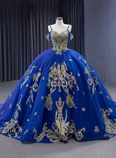 This prom dress, with its intricate gold embellishments, evokes the mystique of a night sky brought to life on fabric. Its corseted bodice, meticulously adorned with sparkling details, sculpts a celestial silhouette. The off-the-shoulder straps add an air of allure, while the expansive skirt unfolds in layers of deep blue tulle, glinting like constellations. Each swirl and step in this gown promises to weave an evening of unforgettable memories, making its wearer the undoubted star of the night. 2023 Ball Gown, Royal Blue Ball Gown, Quinceanera Dresses Blue, White Ball Gowns, Floor Length Wedding Dress, Blue Ball Gowns, Spaghetti Strap Prom Dress, Sequin Prom Dress, Azul Real