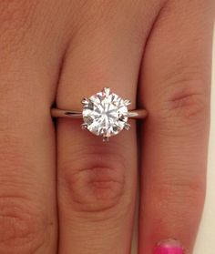 a woman's hand with a diamond ring on it