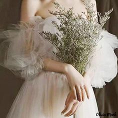 a woman in a white dress holding a bouquet of flowers