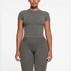 Skims Fits Everybody Tee In Gunmetal Color Size Mz!! Color Is Sold Out On Their Website. Super Stretchy And Comfy! The Smoothing T-Shirt Will Be A Staple In Your Wardrobe. This Crew Neck Short Sleeve Style Features A Body-Hugging Fit That Makes It The Perfect Lounge Top Or Base Layer Under Clothing. Sleek Seamless Workout Tops, Sleek Fitted Top With Seamless Construction, Sleek Stretch Workout Tops, Compressive Crop Top, Sleek Tops With Seamless Construction, Square Neck Bodysuit, Lace Tshirt, Lounge Top, Compression Pants