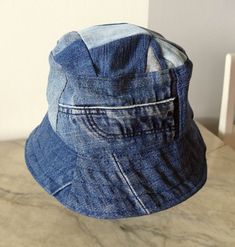 5. Blue jeans bucket hat. For him or her. This hat is made from upcykled blue denim. I sewn it on my lovely vintage sewingmachine. And yes, you can tell this item is handmade and quite unike.  It has a small  zipper pocket and several seams from the fabric, wich use to be trousers. The top of this hat is made from small patches. Inside has a cord in a canal in the lining Inside lining is from light lilac cotton. You can wash in machine, 40 celicius and iron the brim. The brim is sturdy enough to Pre-washed Short Brim Summer Hats, Pre-washed Summer Hat With Short Brim, Summer Pre-washed Short Brim Hats, Summer Short Brim Pre-washed Hat, Adjustable Pre-washed Bucket Hat, Blue Cotton Wide Brim Hat, Adjustable Blue Bucket Hat, Denim Cap For Outdoor, Denim Cap For Outdoor Use