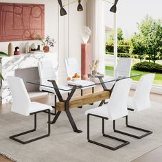 a dining room table with white chairs around it