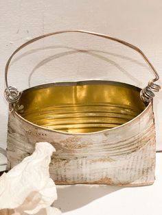 an old metal bucket sitting on top of a table next to a tissue paper dispenser