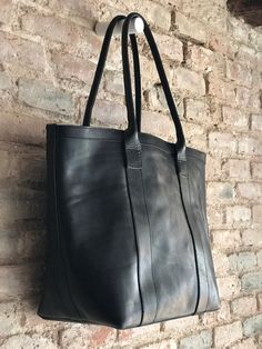 The perfect large carry all bag that will allow to throw in whatever you need to carry with a super stylish look :) Oversized black leather bag, with zipper and inside lining, 1 zippered pocket and 3 open pockets, to keep smaller items separated from the large compartment. If you need a different combination of inside pockets we can also make it :) It's a very versatile bag, you can use it as a weekender, work bag, or a classy diaper bag, with its several pockets, you can have everything organiz Leather Tote Shoulder Bag For Daily Use, Everyday Leather Bucket Bag With Zipper, Travel Tote Bucket Bag With Leather Backing, Everyday Leather Bucket Bag With Zipper Closure, Leather-backed Tote Bucket Bag For Travel, Leather Backing Bucket Bag For Travel, Modern Black Bucket Bag With Leather Lining, Leather Lined Double Handle Bucket Bag, Daily Use Leather-backed Tote Bucket Bag