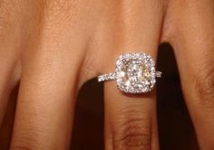 a woman's hand with a diamond ring on her finger and an engagement band