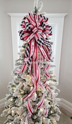 a decorated christmas tree with red, white and black ribbons