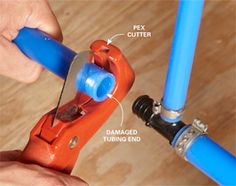 a person is fixing a pipe with blue piping hoses and an orange wrench