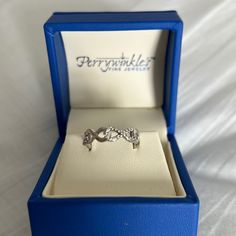 a diamond ring in a blue box on a white sheet with the word perynkler next to it