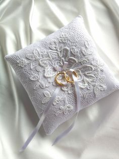 two wedding rings are placed on the pillow